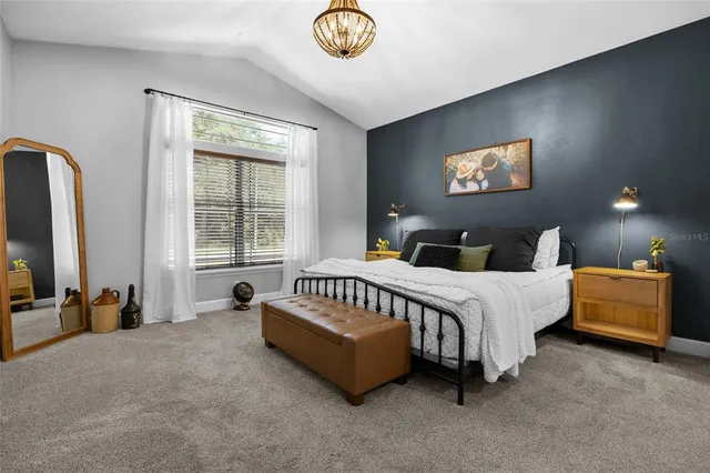 a spacious bedroom with a bed and a chandelier