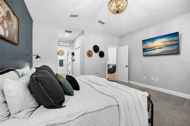 a bedroom with a bed and a painting on the wall