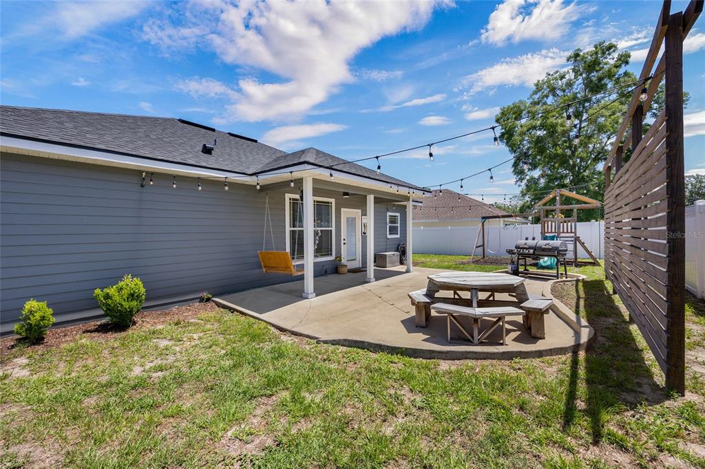 24825 Northwest 201st Road High Springs, FL 32643 - Photo 30 of 31 a view of a backyard with table and chairs and potted plants