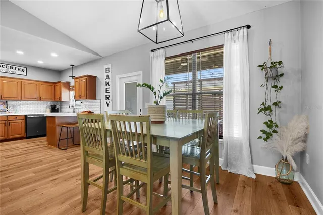 a dining room with furniture potted plants and wooden floor
