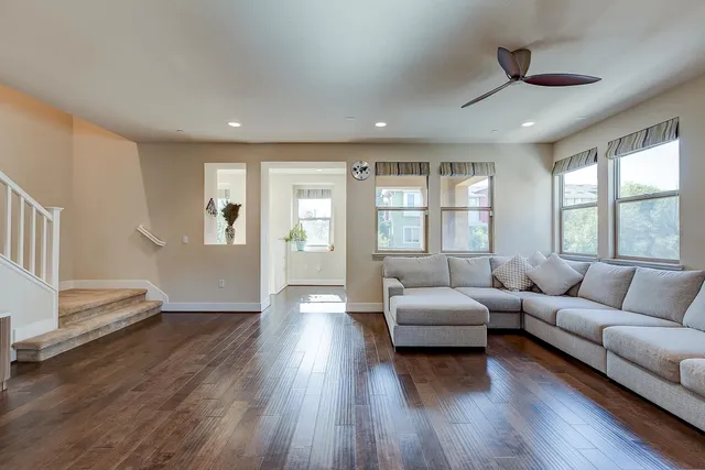 a living room with furniture a flat screen tv and wooden floor