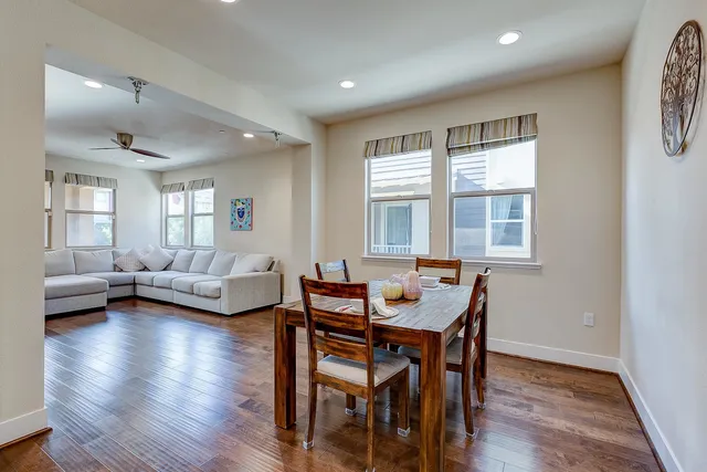 a kitchen with stainless steel appliances a sink a stove a refrigerator cabinets and wooden floor