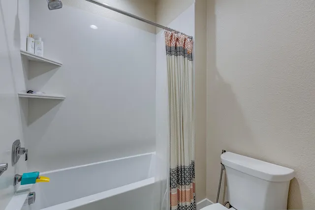 a bedroom with a bed and a ceiling fan