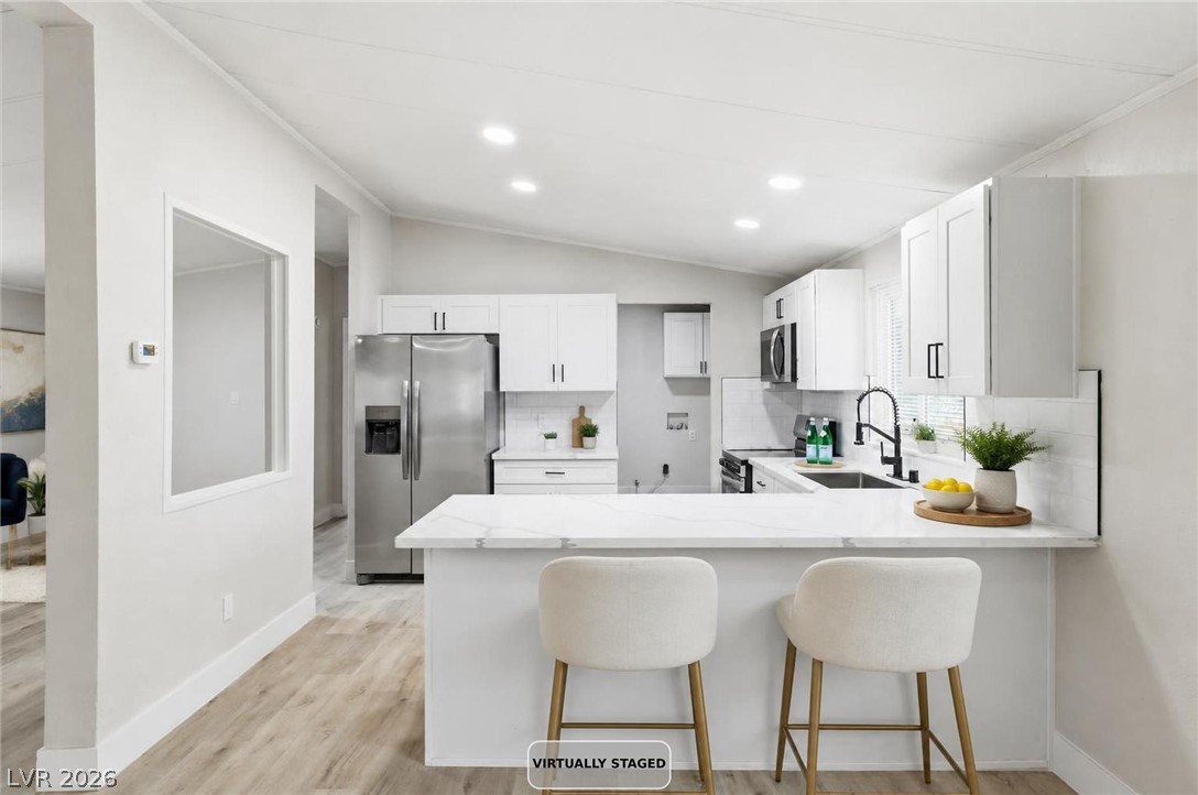3940 Point Drive Pahrump, NV 89060 - Photo 12 of 35 Culinary aspirations come to life in this modern kitchen, showcasing sleek countertops and a convenient breakfast bar.