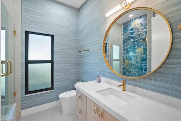 a bathroom with a sink a toilet and a mirror