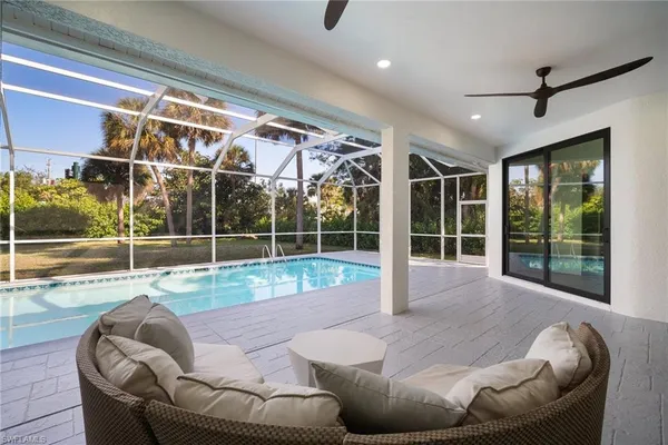 a living room with couch floor to ceiling window and wooden floor