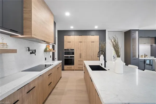 a large white kitchen with sink and a large window