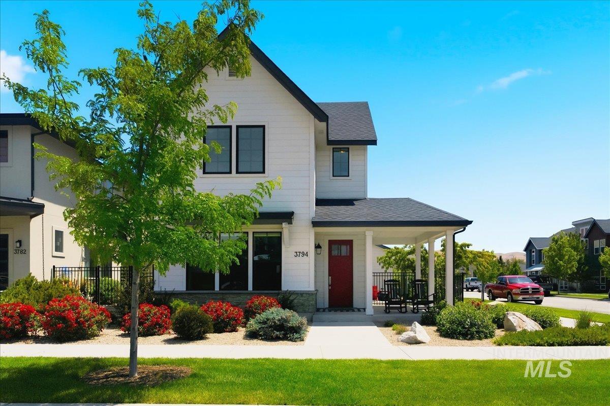 3794 South Single Tree Avenue Boise, ID 83716 - Photo 2 of 50 Contemporary white-sided residence featuring a covered porch with white columns, a vibrant red entry door, and dark-framed windows