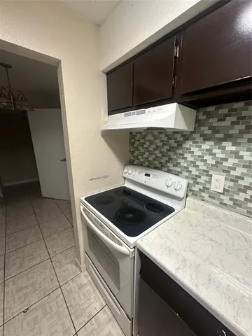 a stove top oven sitting inside of a kitchen