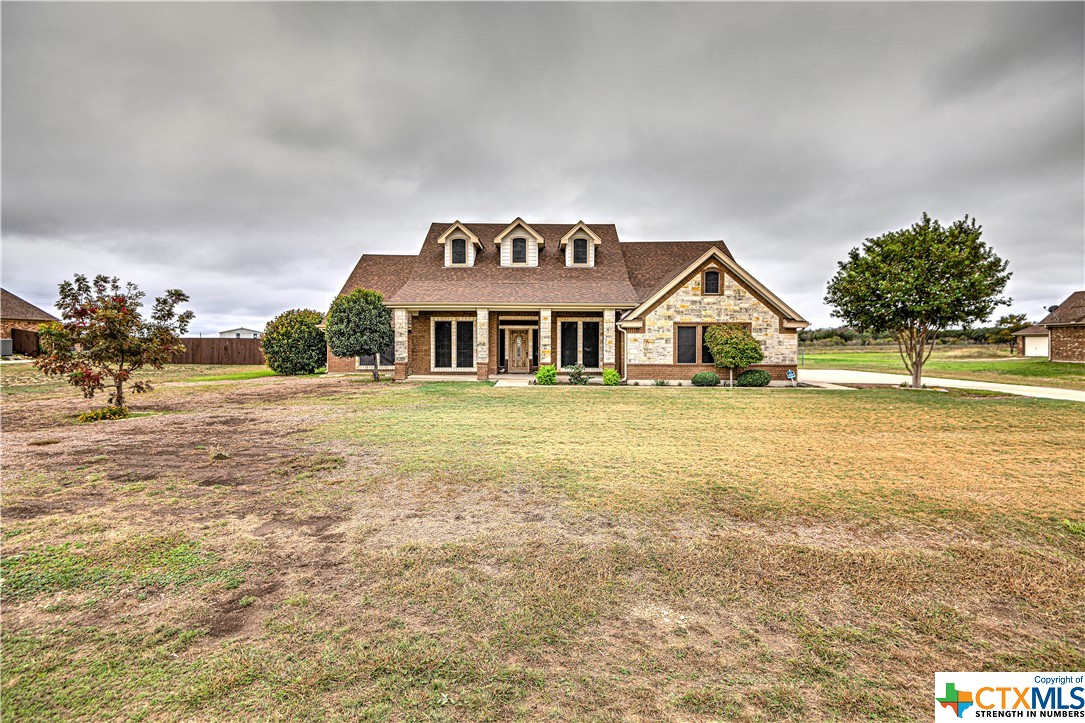 a view of a house with a yard and potted plants