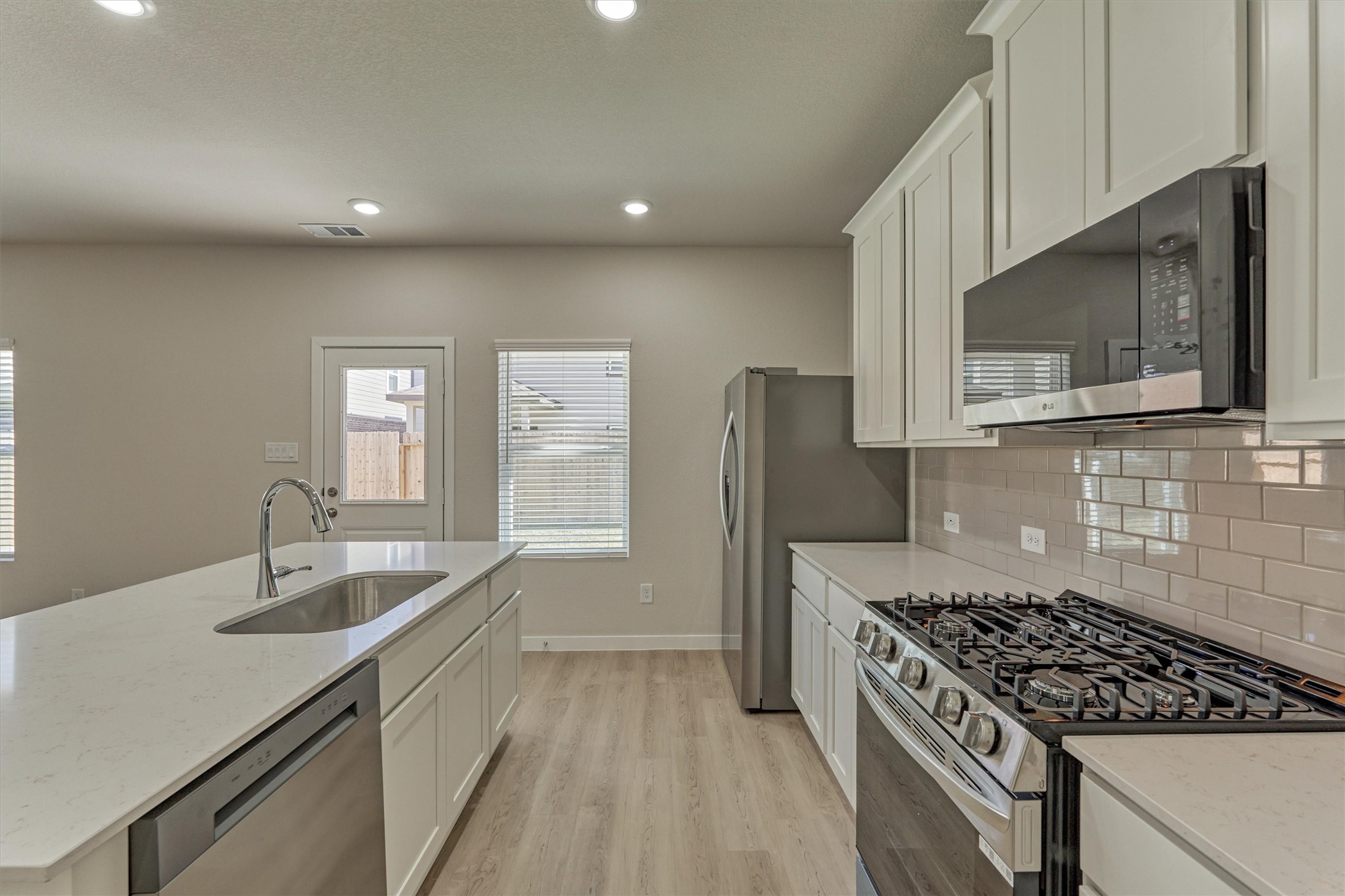 282 Brazen Forest Trail Magnolia, TX 77355 - Photo 16 of 36 a kitchen with granite countertop a sink stove and refrigerator