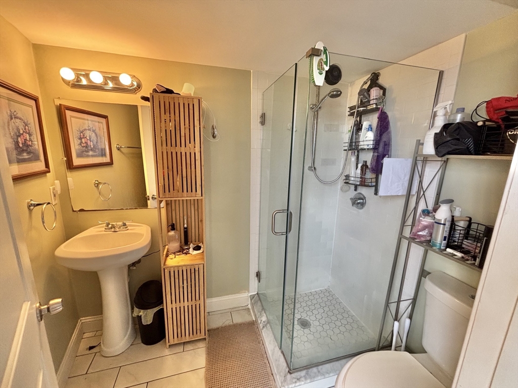 10 Roxbury Street, Unit 10 Boston, MA 02119 - Photo 5 of 8 a bathroom with a sink mirror vanity and toilet
