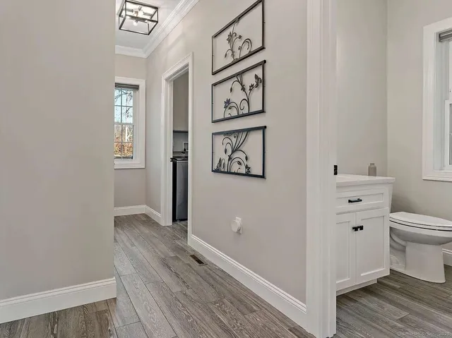 a view of a hallway with wooden floor and closet