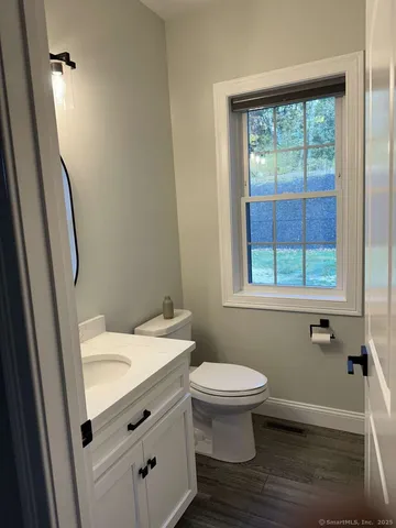 a bathroom with a sink toilet and window