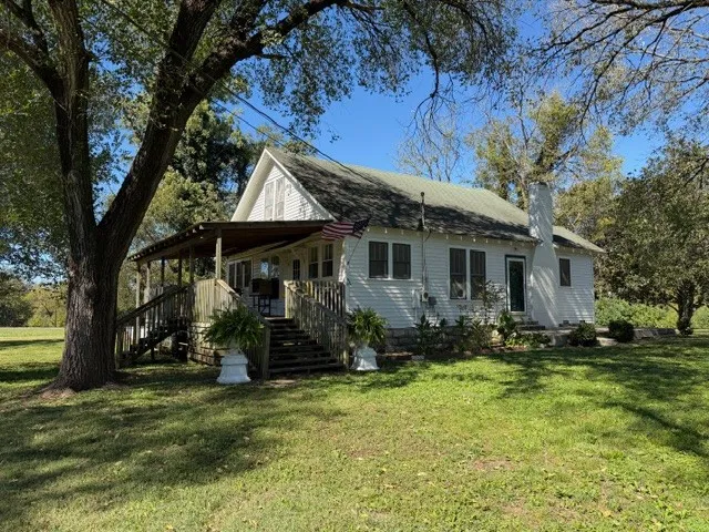 a backyard of a house with yard table and chairs