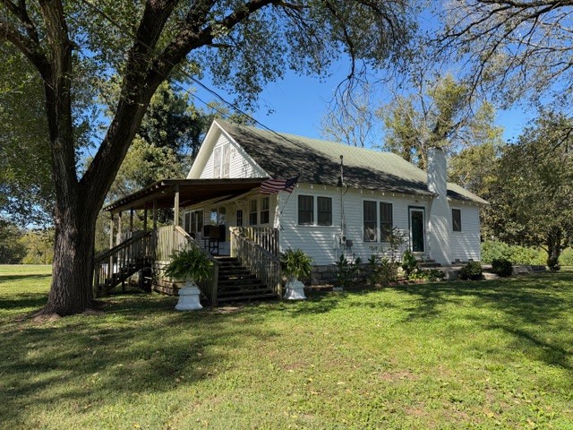 a backyard of a house with yard table and chairs