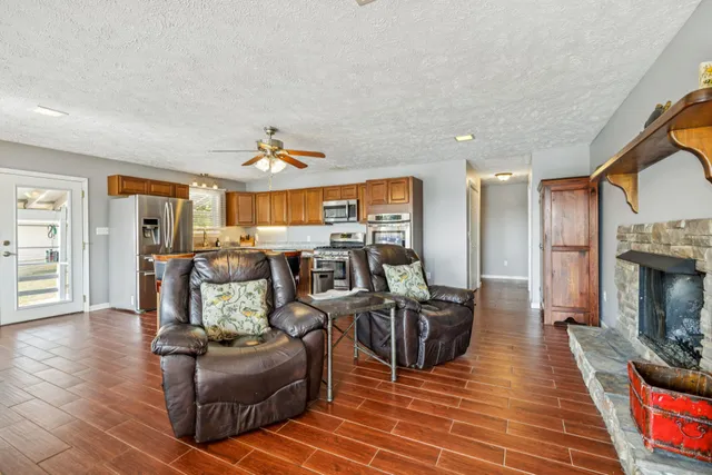 a kitchen with stainless steel appliances granite countertop a stove top oven a refrigerator a sink and dishwasher with wooden floor