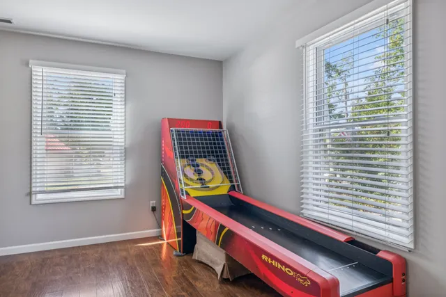 a bathroom with a granite countertop toilet a sink a mirror and a window