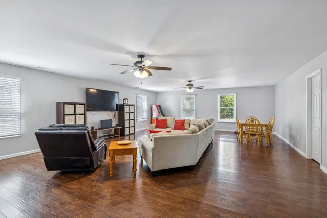 a view of a room with wooden floor and a ceiling fan