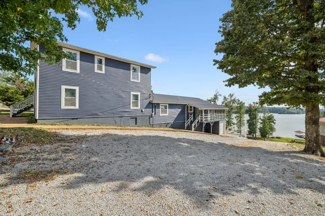 a dining room with wooden floor a chandelier a wooden table and chairs