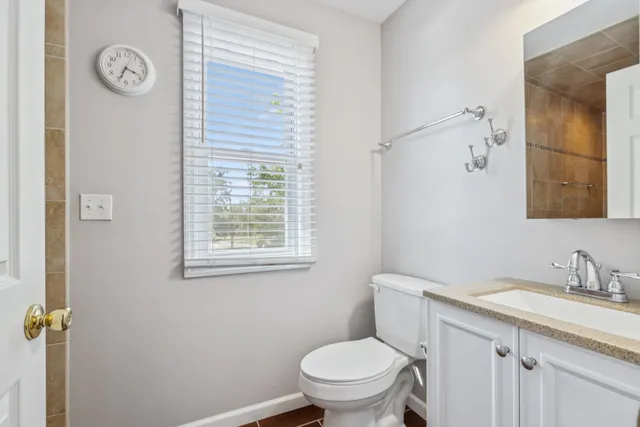 a view of a large pool with lawn chairs under an umbrella