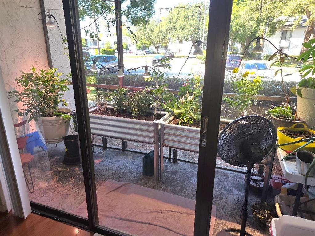 1281 Pine Ridge Circle East, Unit E1 Tarpon Springs, FL 34688 - Photo 11 of 12 a view of a porch with chairs and backyard