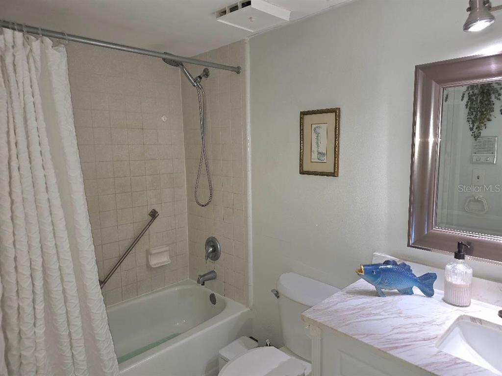 1281 Pine Ridge Circle East, Unit E1 Tarpon Springs, FL 34688 - Photo 7 of 12 a bathroom with a granite countertop bathtub shower sink and toilet