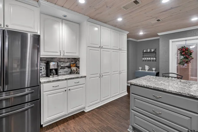 a kitchen with stainless steel appliances granite countertop a refrigerator and a stove top oven