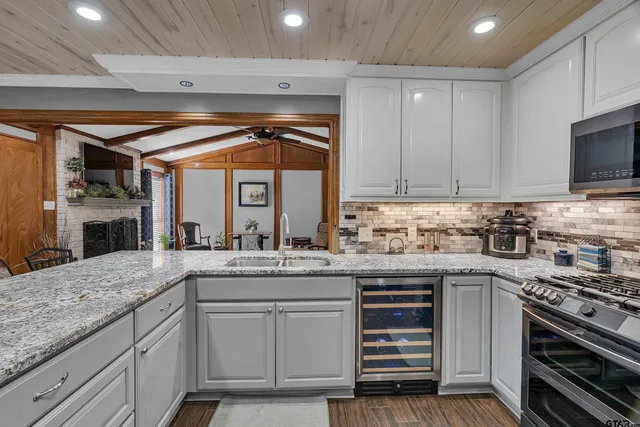 a kitchen with granite countertop a sink stainless steel appliances and cabinets