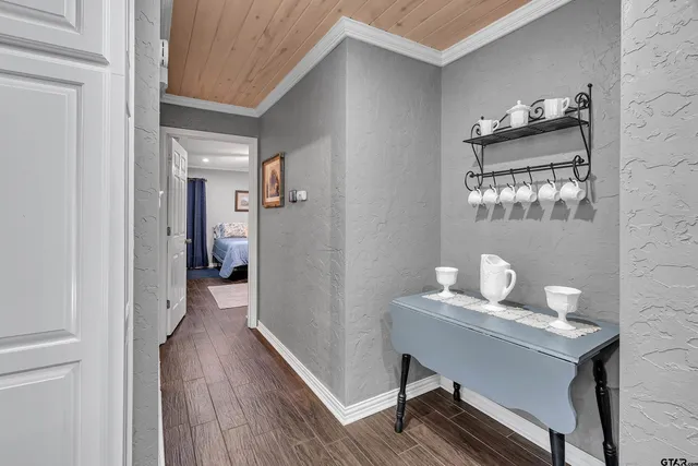 a view of a hallway with wooden floor and a bathroom