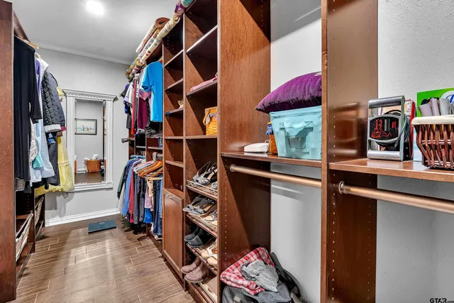a view of walk in closet with clothes and shoes
