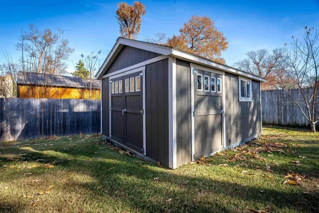 a view of backyard with potted plants and wooden fence