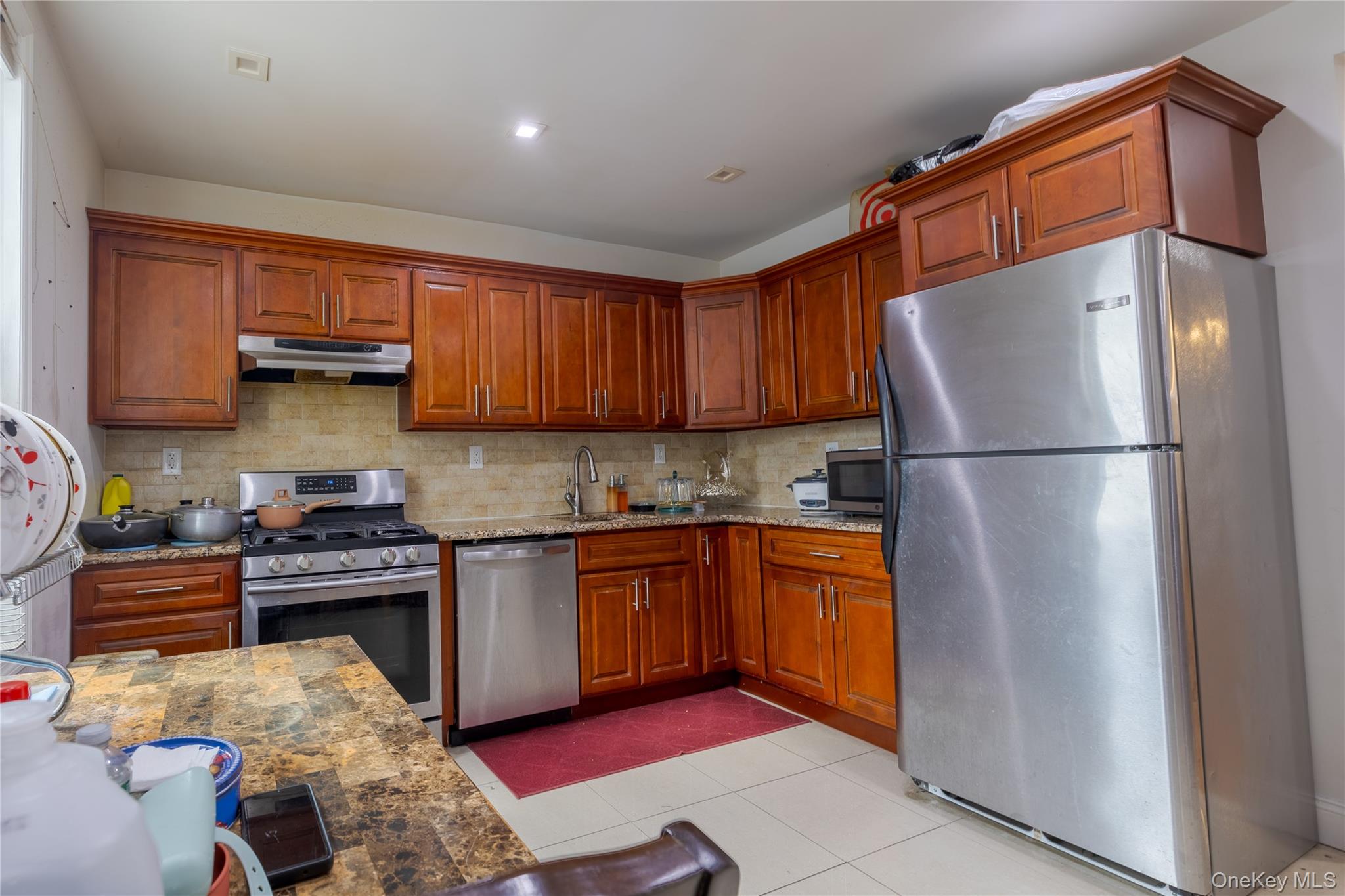 97-14 88th Street Queens, NY 11416 - Photo 6 of 14 a kitchen with stainless steel appliances granite countertop a refrigerator a stove and a sink