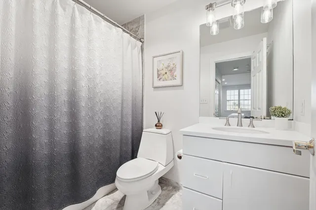 a bathroom with a sink a toilet and shower curtain