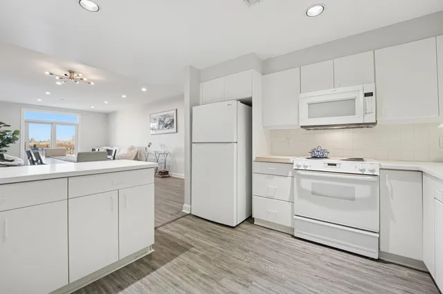 a kitchen with white cabinets and white appliances