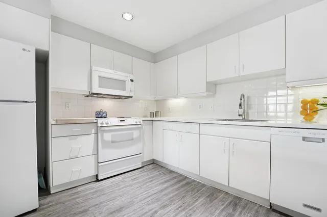 a kitchen with white cabinets and white appliances