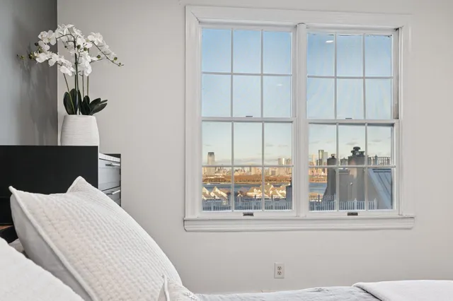a view of a bedroom with wooden floor and a large window