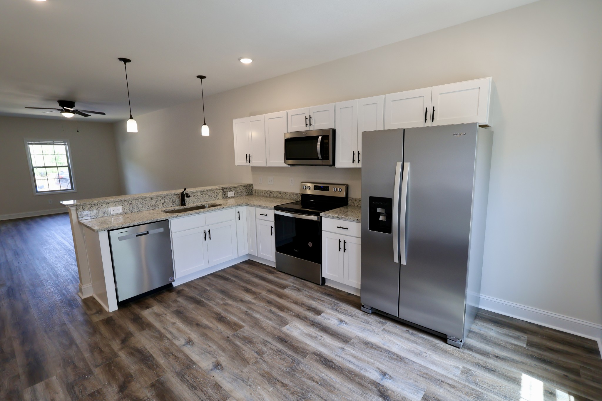 500 Peachers Mill Road, Unit B2 Clarksville, TN 37042 - Photo 9 of 33 a kitchen with stainless steel appliances granite countertop a refrigerator a sink a stove and white cabinets with wooden floor