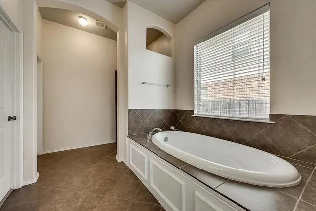 a bathroom with a granite countertop tub and a sink