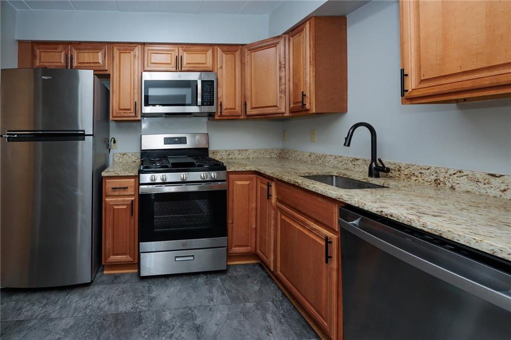 5 Bayard Road, Unit 717 Pittsburgh, PA 15213 - Photo 20 of 46 a kitchen with granite countertop a sink stove and refrigerator
