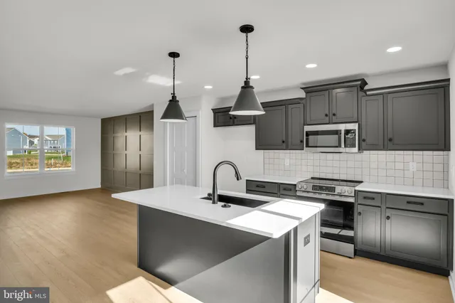 a kitchen with stainless steel appliances granite countertop a sink a stove and a refrigerator