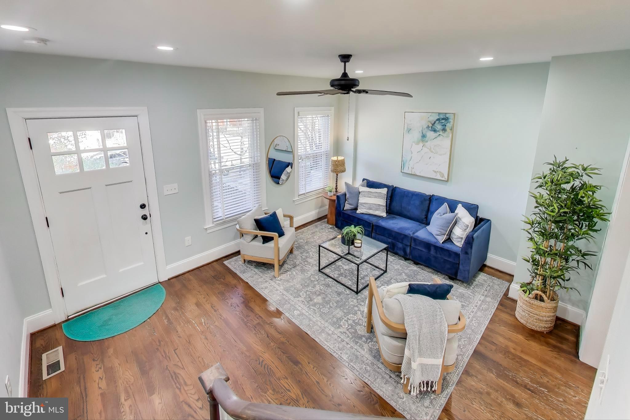 a living room with furniture and a wooden floor