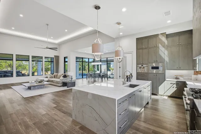 a view of a kitchen with stainless steel appliances granite countertop a stove and a sink