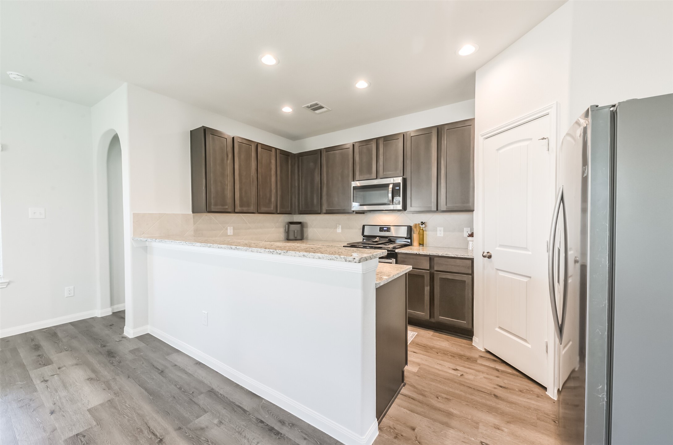 5522 Briana Dee Drive Rosharon, TX 77583 - Photo 12 of 37 a kitchen with a refrigerator sink and wooden cabinets