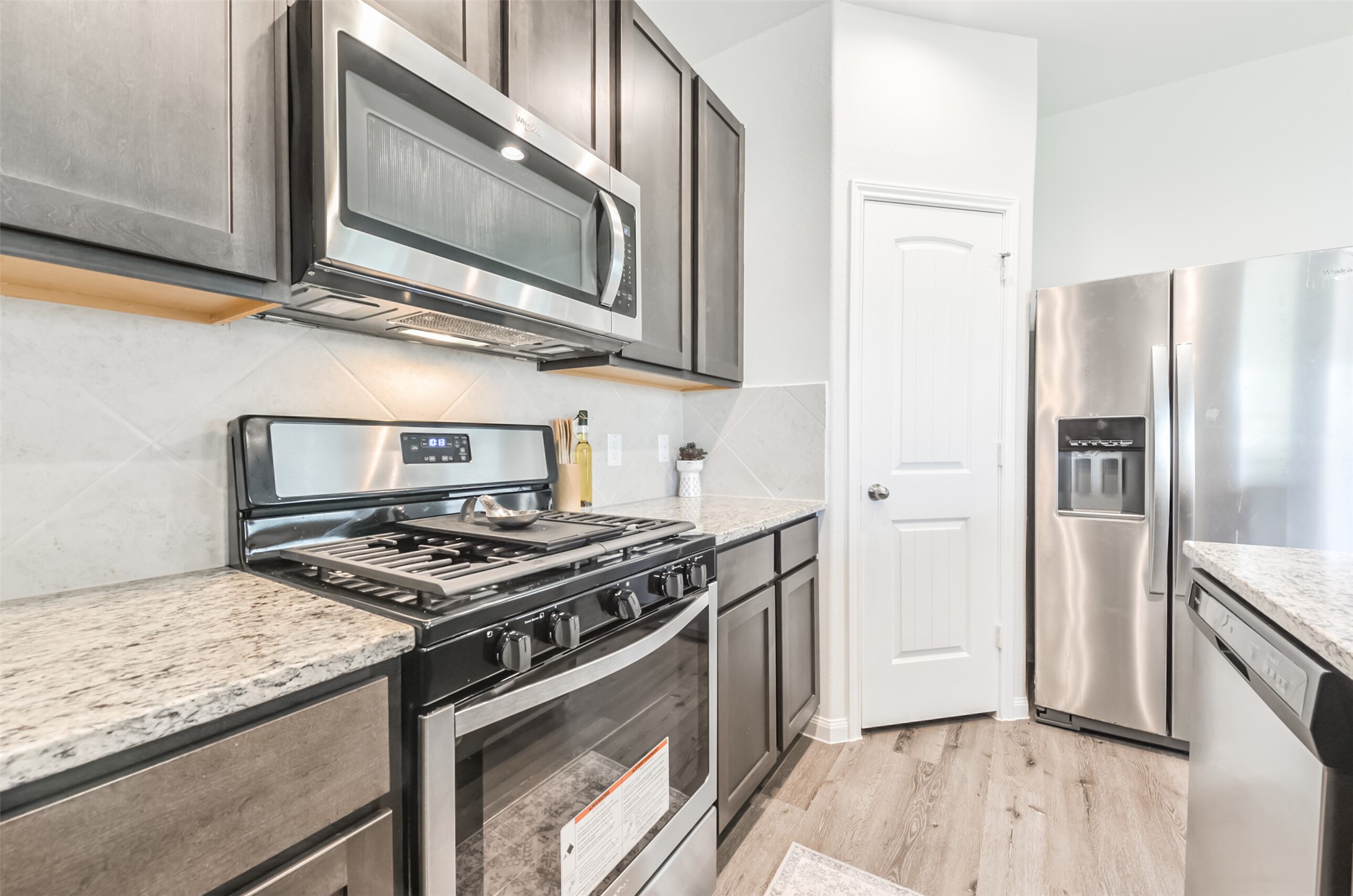 5522 Briana Dee Drive Rosharon, TX 77583 - Photo 17 of 37 a kitchen with stainless steel appliances granite countertop a stove microwave and refrigerator