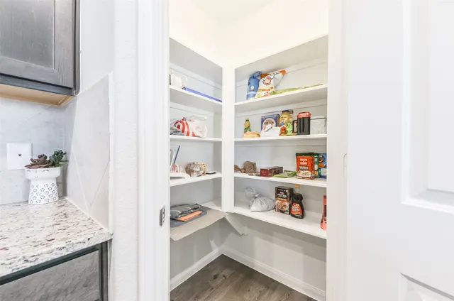 a view of kitchen cabinets with food items with white countertops