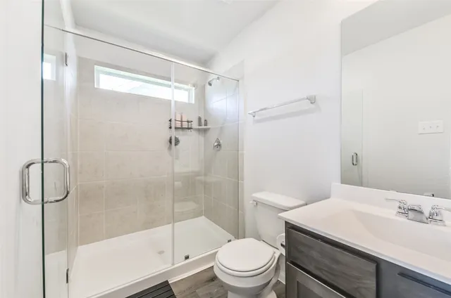 a bathroom with a shower a toilet and sink