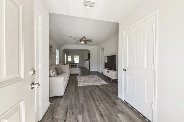 a view of a hallway with wooden floor and staircase