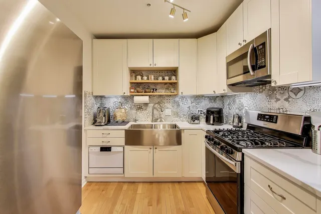 a kitchen with stainless steel appliances a stove microwave and cabinets