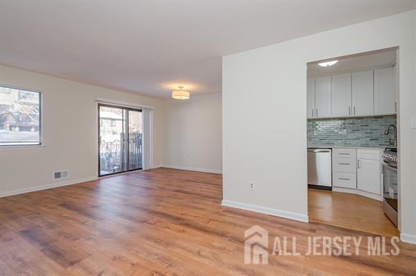 92 Reynolds Court, Unit 147 Old Bridge, NJ 07747 - Photo 9 of 19 a view of an empty room with window and wooden floor